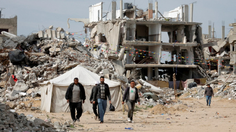 Hombres palestinos caminando cerca de escombros de casas destruidas durante la ofensiva israelí, en Rafah, en el sur de la Franja de Gaza, el 13 de marzo de 2025.
