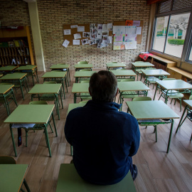 Un profesor en una clase vacía de un colegio. EFE/ Paco Santamaria/Archivo
